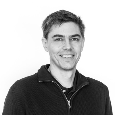 Markus Lagerqvist i svartvitt porträtt. Ler mot kameran.