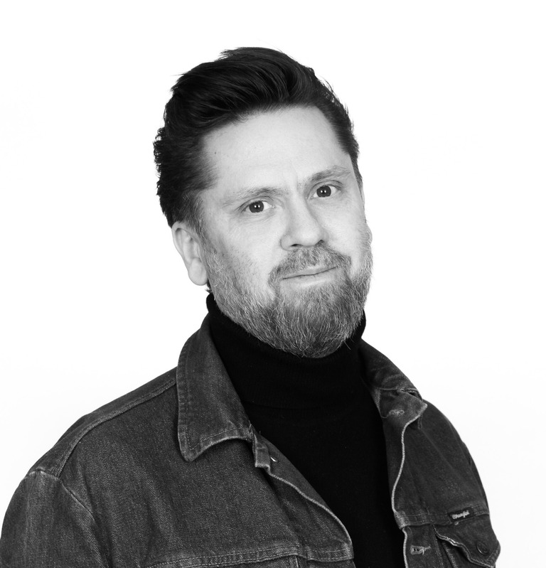 Johan Lager i svartvitt porträtt. Ser in i kameran med ett lätt leende.